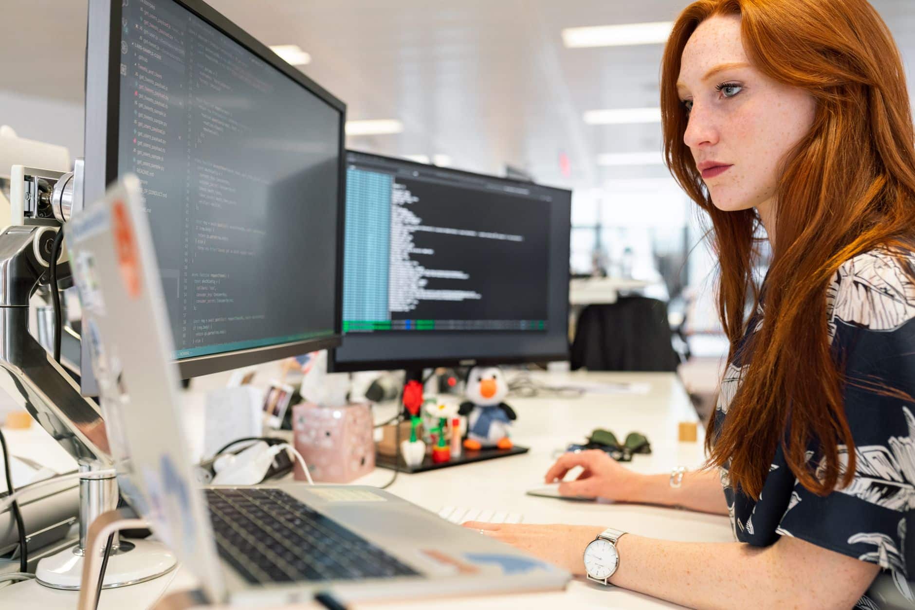 Ingénieure logicielle concentrée devant deux écrans de code